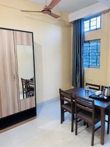 GogāmukhHOTEL CKD的一间带桌椅和镜子的用餐室
