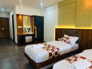 米南加迪Mary Land Residency的一间酒店客房,房间内设有两张床