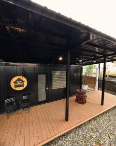 达沃市Cozy Tiny Home with Outdoor Hot Tub in City Center的一个带顶棚的甲板,配有两把椅子和一张桌子