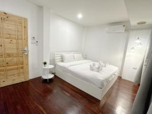 清迈SherVa101 Home and Hostel的卧室配有白色的床,铺有木地板