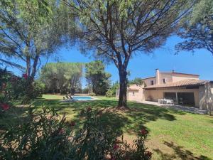 GaronsLa Villa des Pins avec piscine et tennis的一座带游泳池和树木的庭院