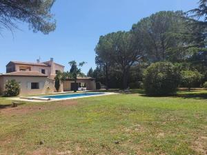 GaronsLa Villa des Pins avec piscine et tennis的一个带房子和游泳池的大院子