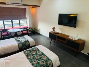 米南加迪Mary Land Residency的酒店客房设有两张床和一台平面电视。