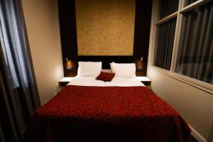 耶路撒冷列夫耶路撒冷酒店的酒店客房,配有一张带红色毯子的床