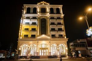 海防Nguyễn Đức DC Hotel & Spa的一座高大的建筑,晚上有灯塔