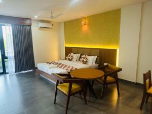 米南加迪Mary Land Residency的卧室配有一张床和一张桌子及椅子