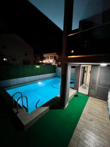 ErdemliMüstakil Alt Kat Havuzlu Villa的夜间房子中间的一个游泳池