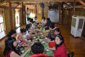 Phú ThọHomestay Long Coc的一群坐在桌子旁吃食物的人