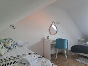 梅尔诺SOLEK Apartamenty i pokoje gościnne的一间卧室配有一张床和一张带镜子的书桌