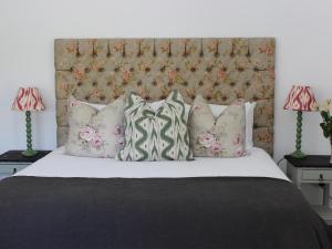 弗朗斯胡克Le Petit Paris的一间卧室配有带枕头的床铺和床头板