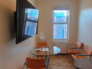 依尔福London Luxury 2 bedroom flat 4 mins to Ilford Stn Sleeps x8 Free Parking的一间会议室,配有玻璃桌和椅子