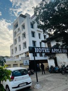 艾哈迈达巴德Hotel Apple Inn的停在酒店前的白色汽车