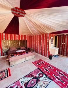 瓦迪拉姆Rum Aranda camp & Jeep Tour的一间卧室配有一张床,地板上铺有2个地毯