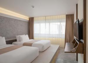 曼谷Nidhra Boutique的酒店客房设有两张床和一台平面电视。