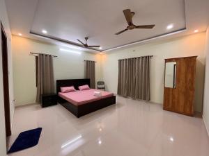 PāngālaUdupi Homestay - Chiradeep Villa的一间卧室配有一张床和吊扇