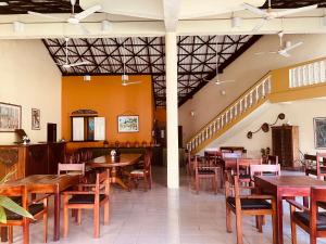 阿鲁特伽马Muthumuni Ayurveda River Resort的一间带木桌和椅子的餐厅,以及楼梯