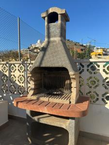 托雷德本纳贾尔邦Casa Pom at the Beach的阳台顶部的石炉