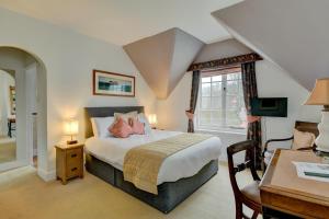 Exford王冠酒店的一间卧室配有一张床、一张书桌和一个窗户。