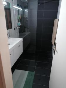 伯尔尼Zimmervermietung Bern的浴室铺有黑色瓷砖地板,配有盥洗盆。