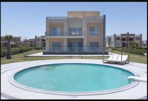 阿莱曼Tolip Resort Sunrays New- Alamein的大楼前的大型游泳池