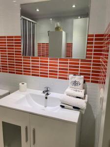 托雷德尔马尔Apartamento SILDA的浴室配有盥洗盆、镜子和毛巾