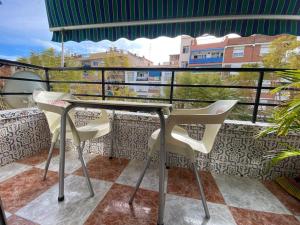 托雷德尔马尔Apartamento SILDA的阳台配有桌子和两把椅子