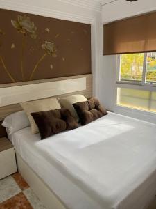 托雷德尔马尔Apartamento SILDA的卧室内的一张带两个枕头的白色床