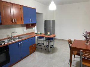 LettomanoppelloCASA MAJA casa per vacanze abruzzo的厨房配有蓝色橱柜和桌椅