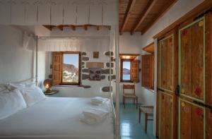 GrikosTheologos Houses的卧室配有白色的床和窗户。
