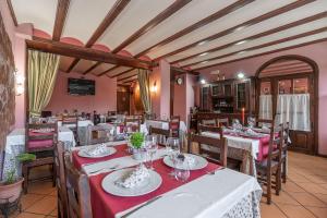 阿尔巴拉辛酒店 - 普拉多那瓦佐餐厅的餐厅配有桌椅和红色桌布