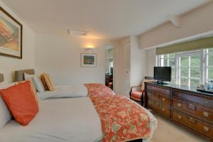 Exford王冠酒店的一间卧室配有一张床和一个带电视的梳妆台