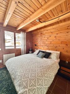卡尼略Exclusiva Cabaña en Vall D'Incles - Pistas de Ski & Vistas al Valle - Parking Incluido的木制客房内的一间卧室,配有一张床