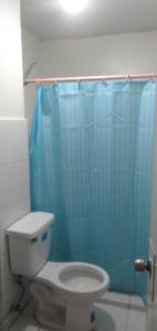 马尼拉Your City•Home Apartment的浴室设有卫生间和蓝色的浴帘。
