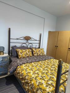 普托莱迈达Polys Apartment and Paraskevi studio with view的一间卧室配有一张带黄色毯子和枕头的床。