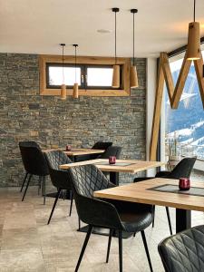拉辛Residence Garni Melcherhof的一间带桌椅的餐厅以及砖墙