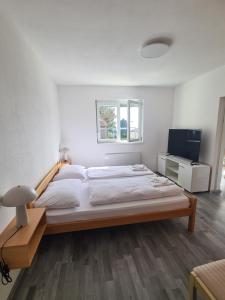 波尔托罗Počitniški dom Portorož / Portoroz Holiday Home的一间卧室配有一张大床和电视