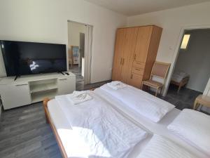 波尔托罗Počitniški dom Portorož / Portoroz Holiday Home的一间卧室配有两张床和一台平面电视