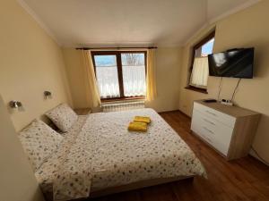 班斯科VV Apartment Bansko的一间卧室配有一张带两张黄色毛巾的床
