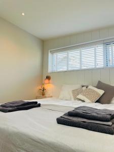 滨海贝亨Villa de Duinfazant的一间卧室设有两张白色的床和窗户