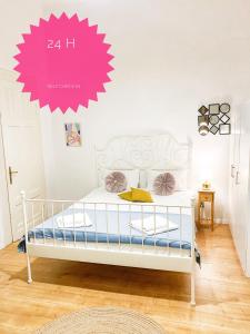 克卢日-纳波卡Perfect Stay的卧室配有白色床,墙上挂着粉红色标志