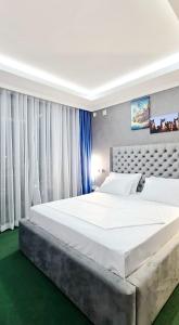 GitegaJerusalem Hotel的白色窗帘的房间的一张大白色床