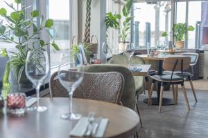 滨海卡特韦克北海酒店的配有桌椅和酒杯的餐厅