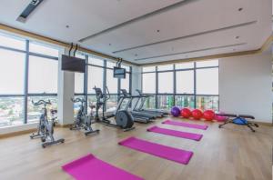 安吉利斯One Euphoria的一个带瑜伽垫和健身器材的健身房,位于带窗户的房间