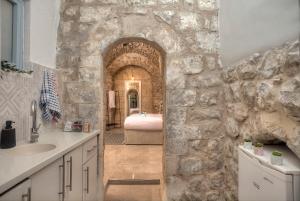 萨法德קשתות - מתחם אבן בצפת העתיקה - Kshatot - Stone Complex in Old Tzfat的浴室设有石墙、水槽和浴缸