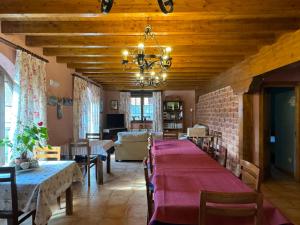 LuzmelaCasa Rural La Socarrena的用餐室配有带红色桌布的长桌