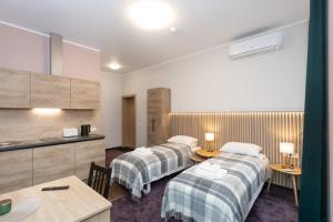 考纳斯Moja Accommodation的酒店客房带两张床和厨房
