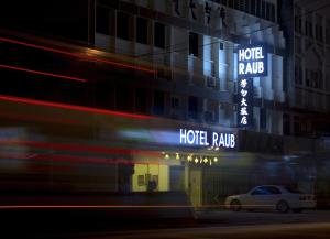 劳勿HOTEL RAUB since 1968的旁边是一座有 ⁇ 虹灯标志的酒店大楼
