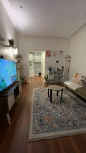 利雅德Secret Garden Studio استوديو بمدخل جانبي خاص ودخول ذكي的客厅配有平面电视和沙发。