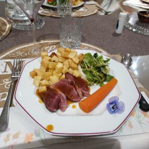 MontiratLa Douce Parenthèse - 3 chambres d'hôtes-Accueil motards的桌上一盘带肉和蔬菜的食物
