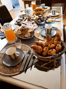 MontiratLa Douce Parenthèse - 3 chambres d'hôtes-Accueil motards的包括糕点、咖啡和橙子的早餐桌 果汁